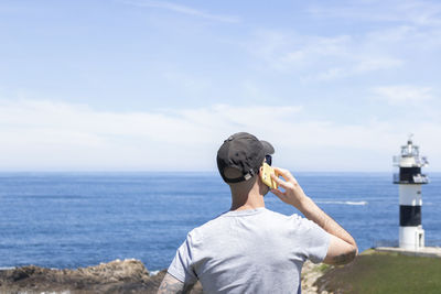 Man standing by sea against sky