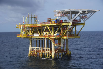 Offshore platform in sea against sky