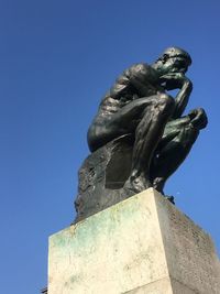 Low angle view of statue against blue sky