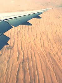 Airplane flying over landscape against sky