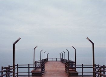 Staircase by sea against sky