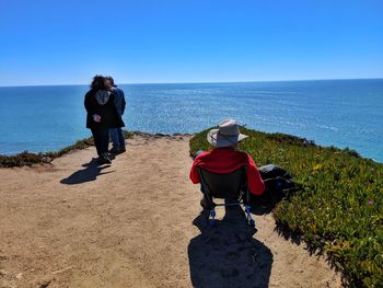 People on cliff by sea