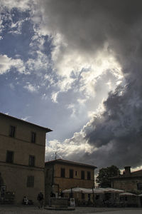 Buildings against cloudy sky