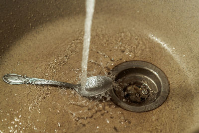 High angle view of faucet in water