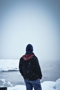 Man on snow covered landscape against sky