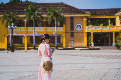 Woman using phone while standing outdoors