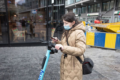 Brussels belgium - 01.31.2022 a young woman in a warm down jacket and a mask