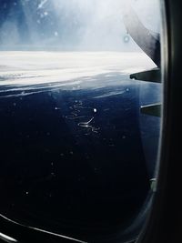 Airplane flying over sea against sky