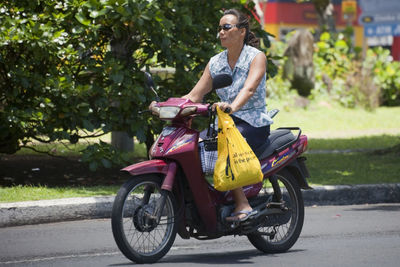 Woman riding motorcycle on road