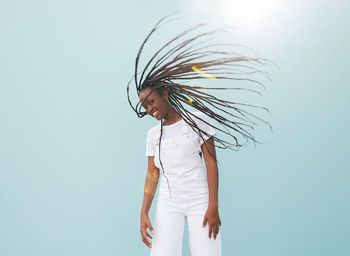 Rear view of woman standing against blue background