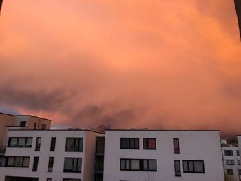 Low angle view of buildings against dramatic sky