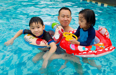 Smiling family in swimming pool