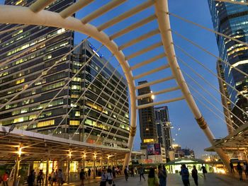 People on illuminated modern buildings in city