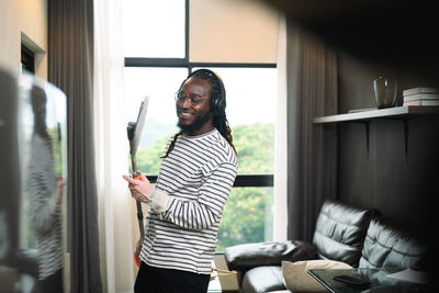 Side view of young woman standing by window