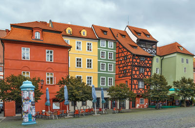 Residential buildings by street against sky