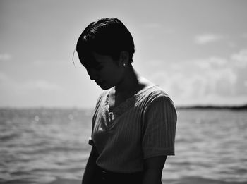 Portrait of teenage girl looking at sea shore against sky