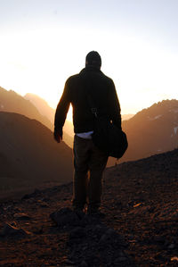 Rear view of man looking at mountain against sky