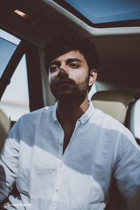 Thoughtful young man sitting in car