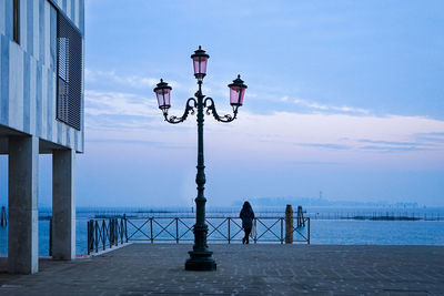 Street light by sea against sky