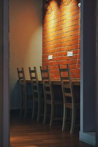 Empty chairs and table against wall