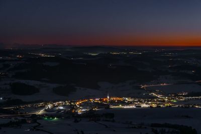 High angle view of illuminated city against sky at sunset