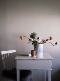 Potted plant on table against white wall