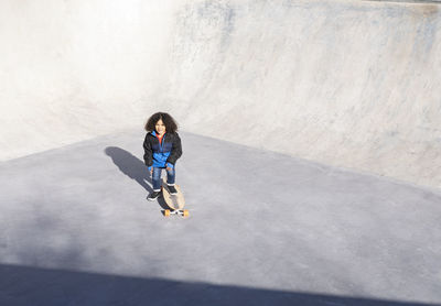 Full length of man skateboarding on concrete wall
