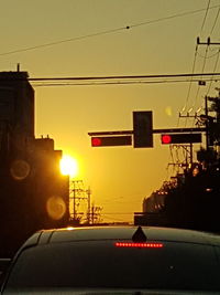 Car on illuminated city against clear sky during sunset