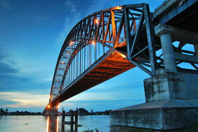 Low angle view of bridge over river against sky