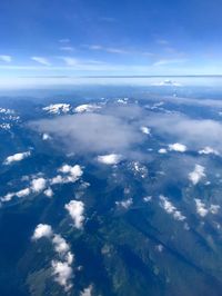 Aerial view of landscape and sea against blue sky