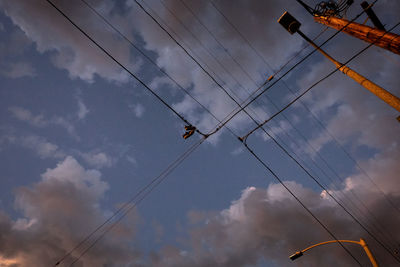 Low angle view of electricity pylons against sky