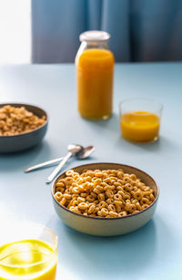 Breakfast concept with cold cereals and orange juice on blue background