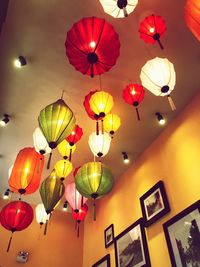 Low angle view of illuminated pendant lights hanging on ceiling