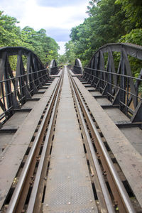 Railroad tracks amidst trees against sky