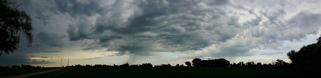 Scenic view of field against cloudy sky