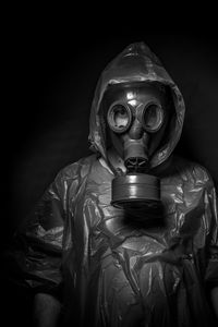 Man wearing gas mask against black background