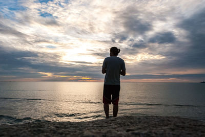 Rear view of man standing on beach