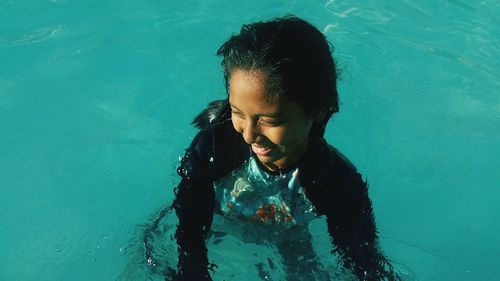 High angle view of smiling young woman in swimming pool