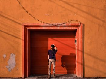 Man standing against entrance of building