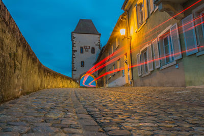 Street amidst buildings in city at dusk