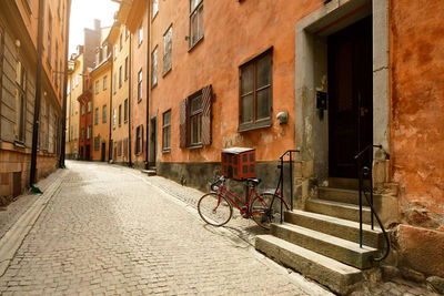 Bicycle parked on street amidst buildings