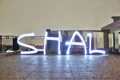 Illuminated text on wall in building at night