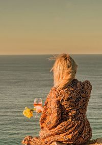 Rear view of woman looking at sea against sky