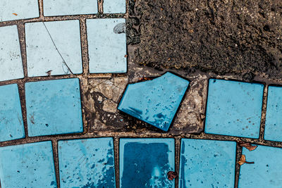 High angle view of damaged tile on footpath