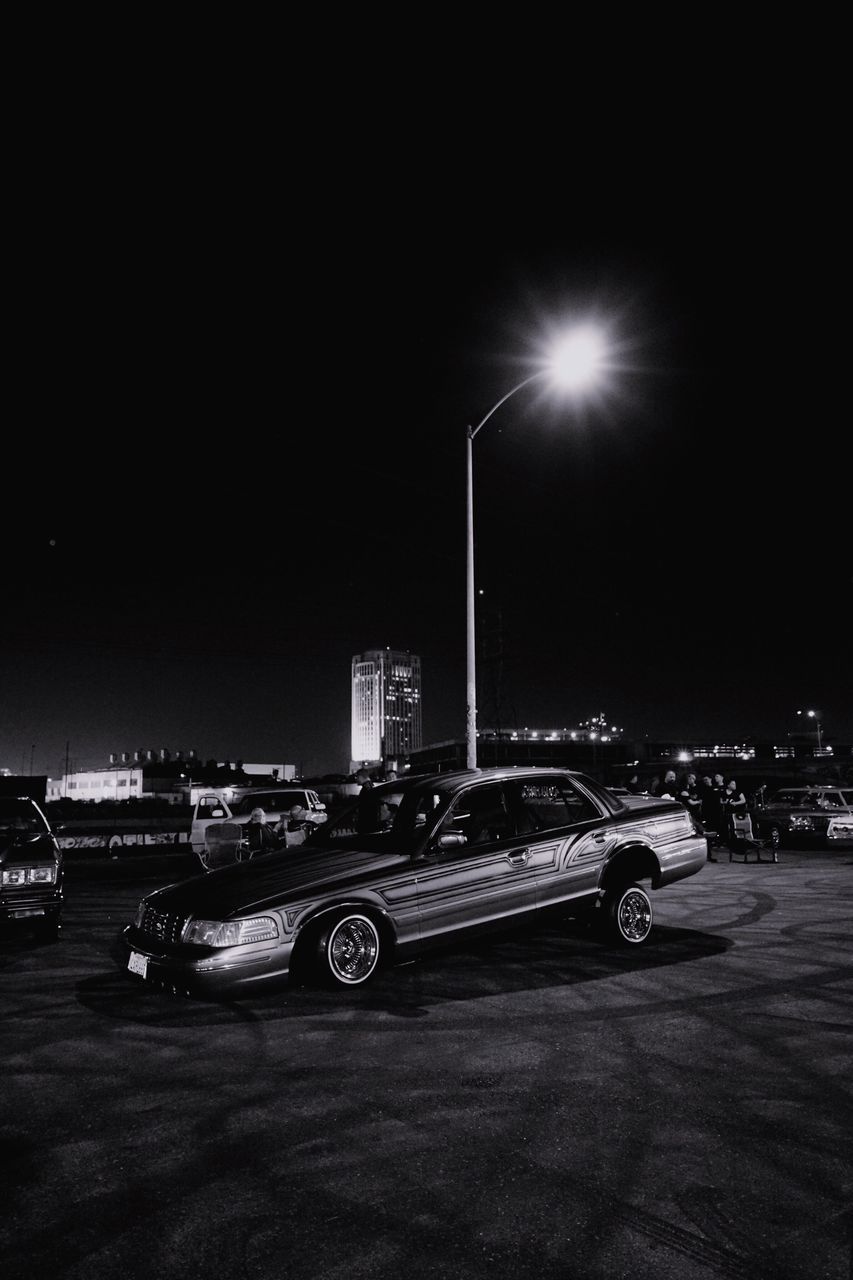 CAR ON ILLUMINATED STREET AT NIGHT