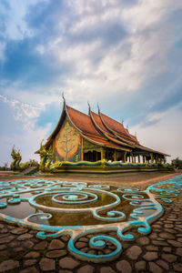 View of temple building against cloudy sky