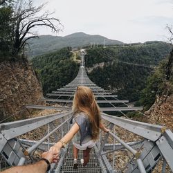 Rear view of woman on mountain against sky
