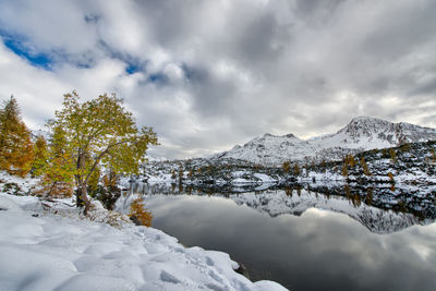 Mountains reflected in the lake with the first snow fall
