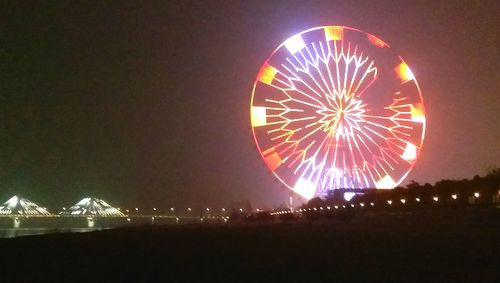 Illuminated ferris wheel at night