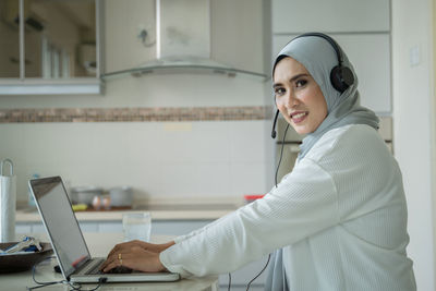 Side view of a young woman using phone